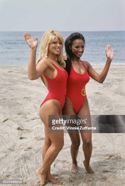 American actress and glamour model Donna D'Errico and American actress Traci Bingham, each wearing a red swimsuit, attend a 'Baywatch' press event to...