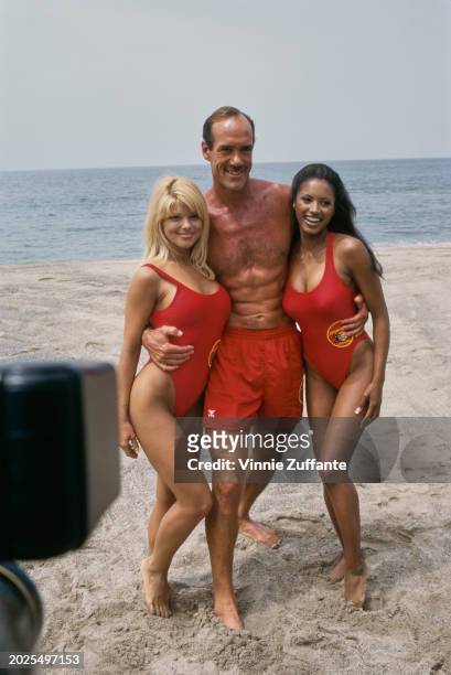 American actress and glamour model Donna D'Errico, wearing a red swimsuit, American actor and lifeguard Michael Newman, and American actress Traci...
