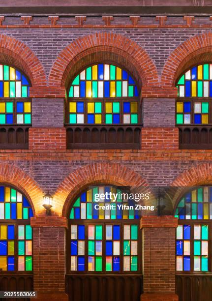 arched stained glass windows on retro brick wall in xijindu ancient street - stained glass door stock pictures, royalty-free photos & images