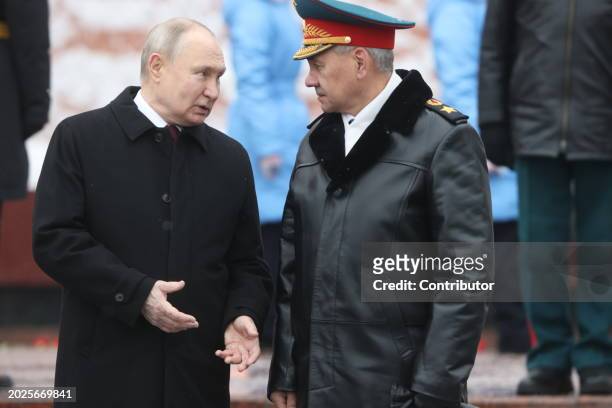 Russian President Vladimir Putin listens to Defence Minister Sergei Shoigu while taking part in the wreath laying ceremony at the Unknown Soldier...
