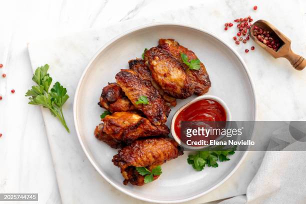 spicy chicken wings in bbq sauce at white table - roast dinner pub stock pictures, royalty-free photos & images
