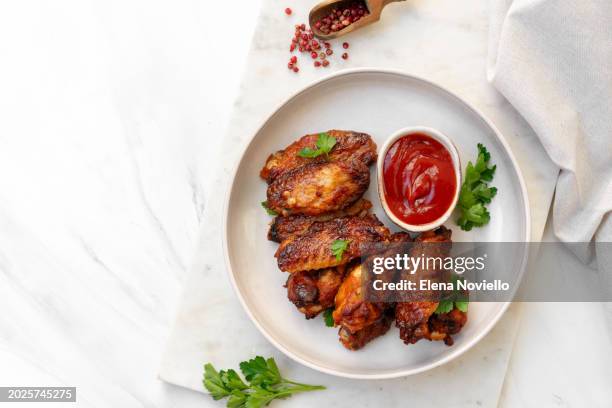 spicy chicken wings in bbq sauce at white table - roast dinner pub stock pictures, royalty-free photos & images