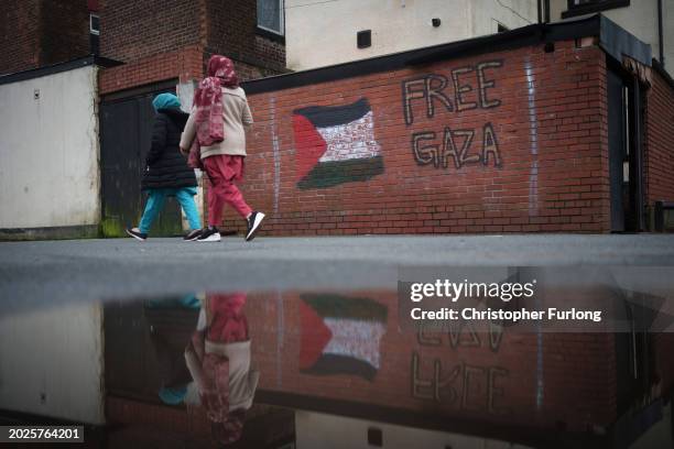 People walk past pro-Palestinian graffiti in Rochdale on February 19, 2024 in Rochdale, England. Galloway, a former Labour and Respect Party MP, now...