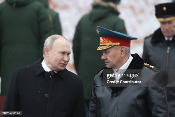 Russian President Vladimir Putin speaks as Defence Minister Sergei Shoigu looks on while taking part in the wreath laying ceremony at the Unknown...