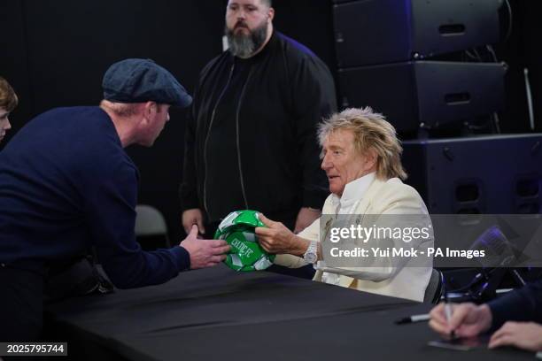 Rod Stewart signs a Celtic FC football during a signing session with Jools Holland for their new collaborative studio album Swing Fever, at HMV...