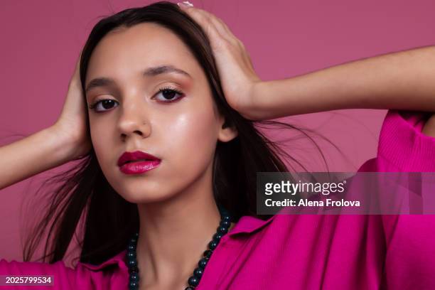 beautiful  young woman standing and smiling and dressing magenta jumper, leather trousers pink background springtime facial emotion fashion beauty - teen boots russian stock pictures, royalty-free photos & images