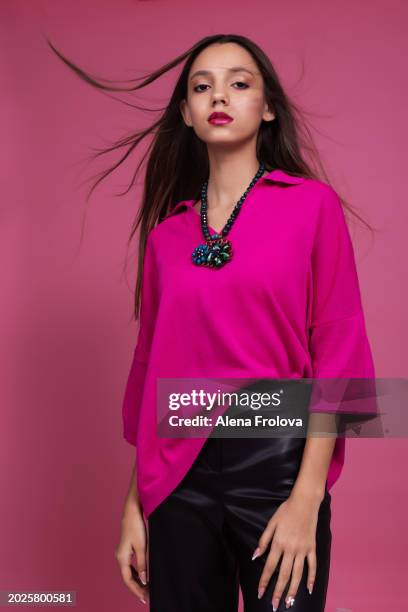 beautiful  young woman standing and smiling and dressing magenta jumper, leather trousers pink background springtime facial emotion fashion beauty - teen boots russian stock pictures, royalty-free photos & images