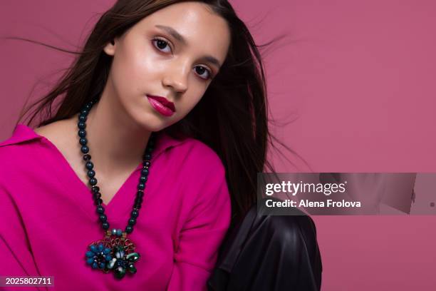 beautiful  young woman standing and smiling and dressing magenta jumper, leather trousers pink background springtime facial emotion fashion beauty - teen boots russian stock pictures, royalty-free photos & images