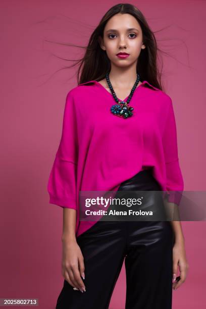 beautiful  young woman standing and smiling and dressing magenta jumper, leather trousers pink background springtime facial emotion fashion beauty - teen boots russian stock pictures, royalty-free photos & images