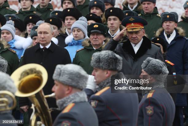 Russian President Vladimir Putin and Defence Minister Sergei Shoigu look on while taking part in the wreath laying ceremony at the Unknown Soldier...