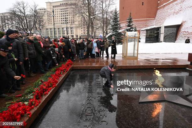 Russian Communist supporters lay flowers at the Tomb of the Unknown Soldier by the Kremlin Wall to mark the Defender of the Fatherland Day in Moscow...