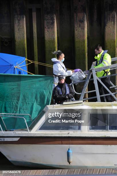 Member of the forensic team places evidence in plastic evidence bags and hands it over to police officers on February 23, 2024 in Wisbech, England. A...