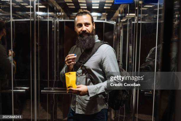 mature man eating snack on the go - coco stock pictures, royalty-free photos & images