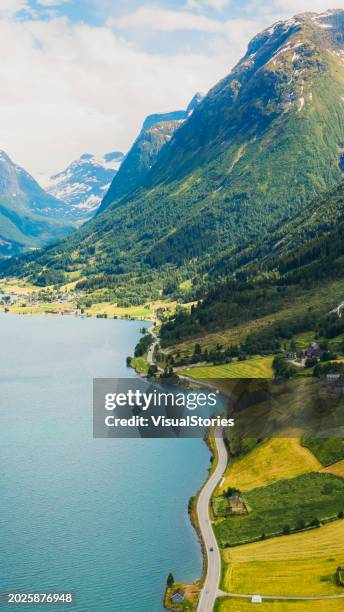 vista aerea dell'auto che guida nel paesaggio estivo panoramico del fiordo blu cristallo con vista sulle montagne in norvegia - olden foto e immagini stock