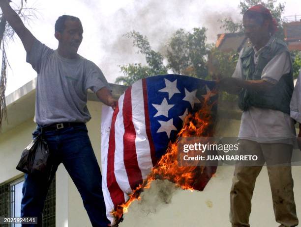 Young men burn the American flag in front of the Cuban embassy in Caracas, Venezuela, cheering in favor of Cuban President Fidel Castro, 26 May 2001,...