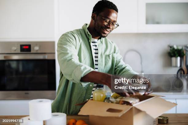 man donating food for poor people - man holding donation box stock pictures, royalty-free photos & images