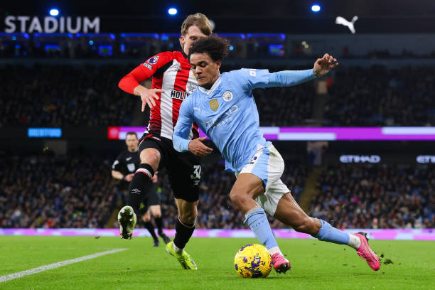 Oscar Bobb of Manchester City battles for possession with Mads Roerslev of Brentford during the Premier League match between Manchester City and...