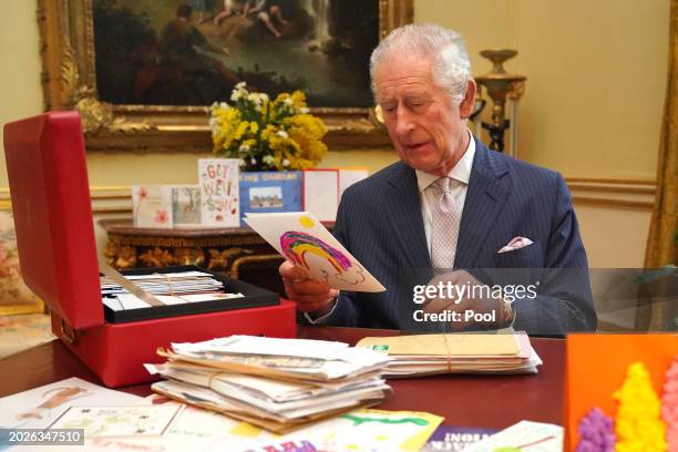 In this photo released on February 23, King Charles III reads cards and messages, sent by well-wishers following his cancer diagnosis, in the 18th...