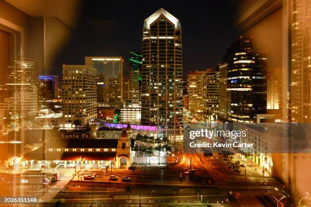 Seen through a hotel window at night, the Santa Fe Depot train station is located near the 34-story One America Plaza, center, in downtown San Diego...