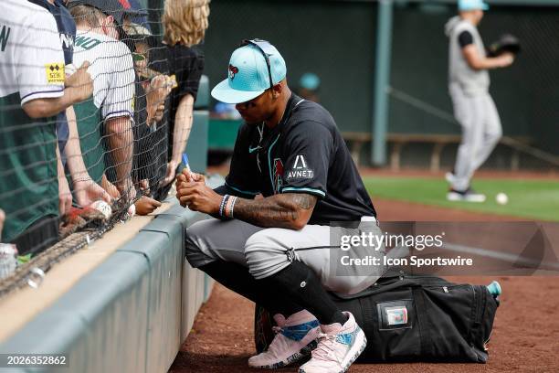 Arizona Diamondbacks catcher Tucker Barnhart signs autographs before the MLB spring training baseball game between the Arizona Diamondbacks and the...