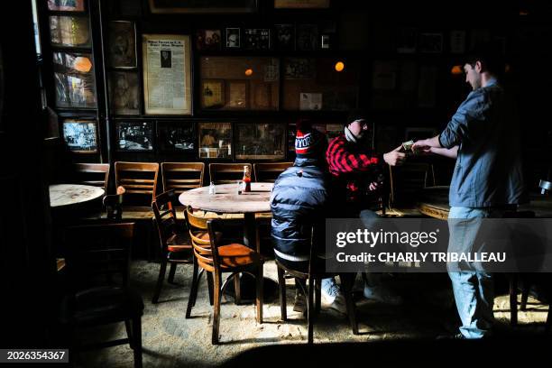 Customers pay for beer at McSorley's Old Ale House in New York on February 22, 2024. Not much has changed in the 170 years that McSorley's OLD Ale...