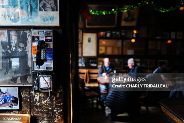 An public phone is seen on the wall as customers drink beers at McSorley's Old Ale House in New York on February 18, 2024. Not much has changed in...