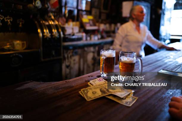 Beers and US dollars bills are seen on the counter at McSorley's Old Ale House in New York on February 18, 2024. Not much has changed in the 170...