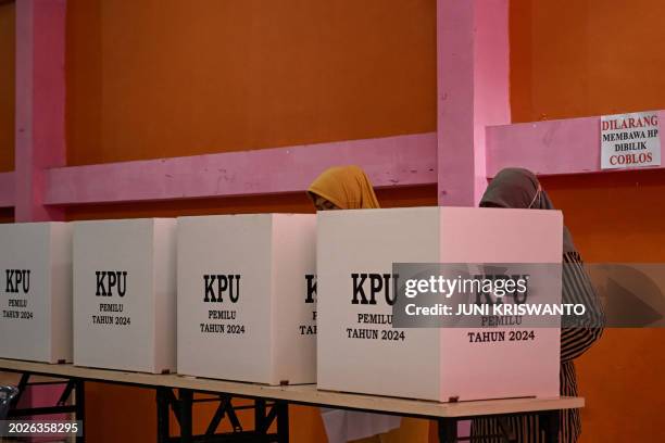 Voters mark their ballots during a revote in Surabaya on February 24 following logistical problems which affected some ten polling stations in the...