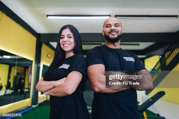 portrait of personal trainers at the gym - vrijetijdsfaciliteiten stockfoto's en -beelden