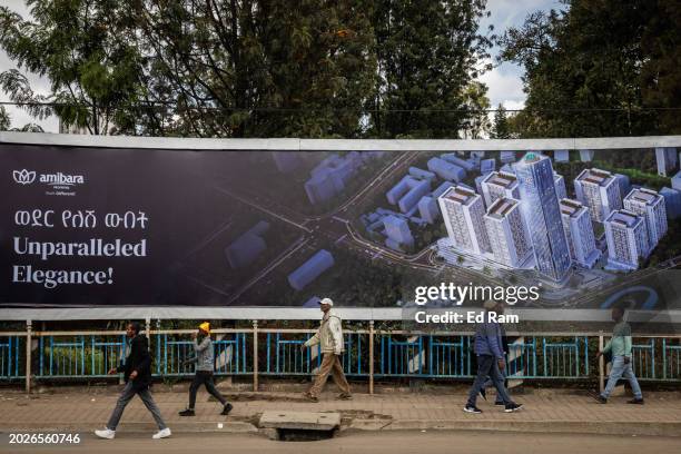 People walk past billboard advertising a building development on February 14, 2024 in central Addis Ababa, Ethiopia. More than 20 million Ethiopians...