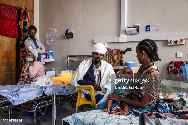 Tsige Nerae sits with her husband and son Selam Gebremikael who is suffering from hydrocephalus caused by maternal malnutrition according to the...