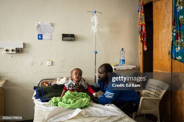 Girmay Gebreannia looks after his son Medihin Girmay, who is suffering from hydrocephalus caused by maternal malnutrition according to the doctors in...