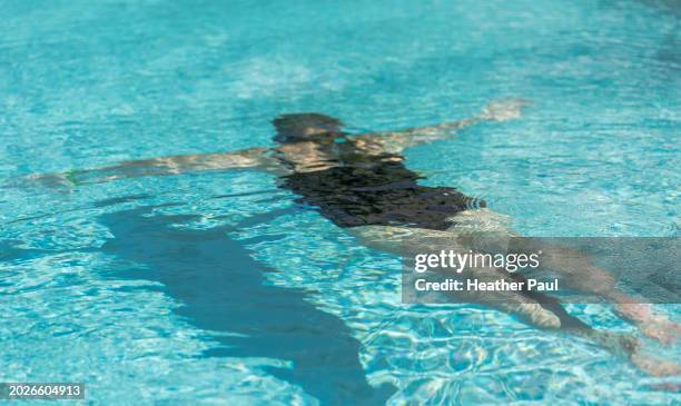 mature woman swimming underwater at a swimming pool - guerrero stock pictures, royalty-free photos & images