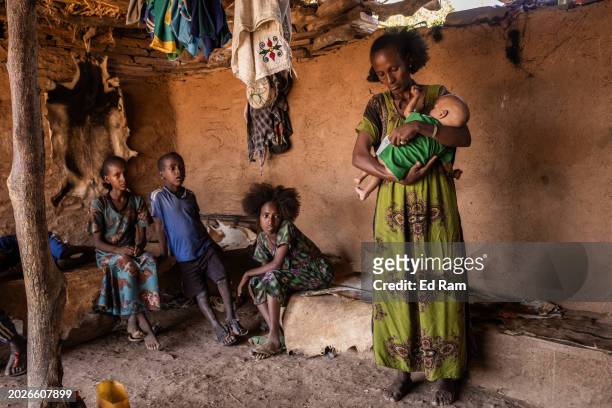 Muley Gebremedhin holds her malnourished 11-month old daughter Selam Belayneh in the Yechila district on February 18, 2024 in Tigray Region,...