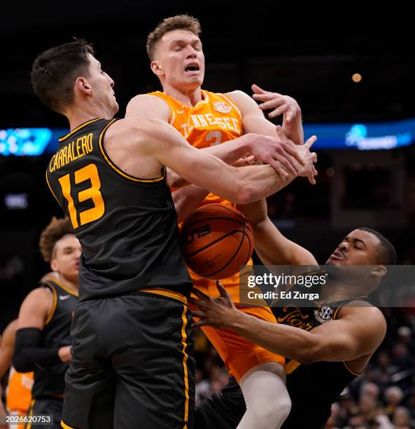 Dalton Knecht of the Tennessee Volunteers is stripped of the ball by Jesus Carralero Martin and Nick Honor of the Missouri Tigers in the second half...