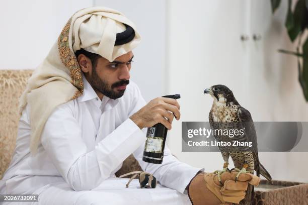 Man sits in a waiting room with his falcon as it awaits treatment, at the Souq Waqif Falcon Hospital on February 09, 2024 in Doha, Qatar.