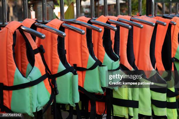 colorful life jackets hanging in a row near swimming pool - life jacket isolated stock pictures, royalty-free photos & images