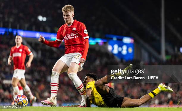 Ian Maatsen of Dortmund slides down next to Jerdy Schouten of Eindhoven during the UEFA Champions League 2023/24 round of 16 first leg match between...
