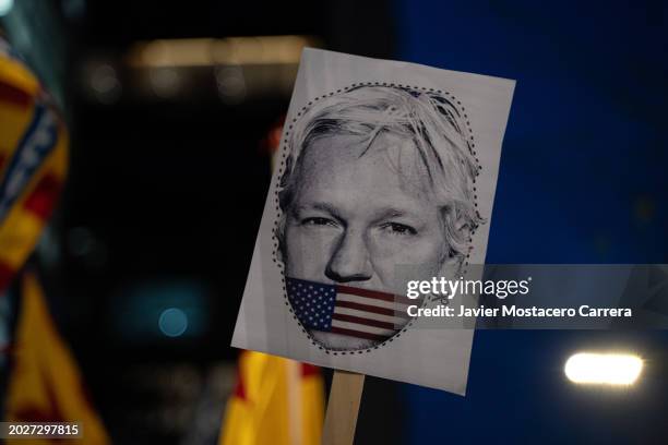 Person holds a banner with Julian Assange's face in front of the UK consulate to protest against the extradition of Julian Assange to the USA on...