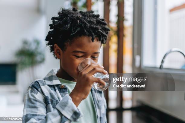 portrait child boy drinking water at home - drinkwater stockfoto's en -beelden