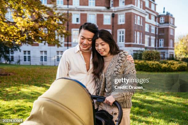 famiglia asiatica con bambino che cammina nel parco, spingendo il passeggino e godendosi la soleggiata giornata autunnale - i-love-you-frase-inglese foto e immagini stock