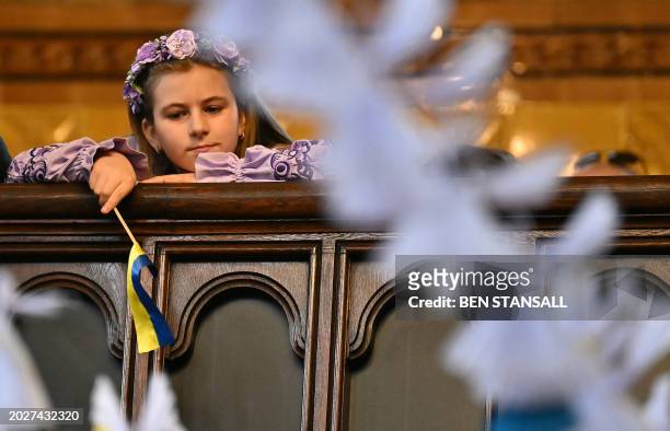 Young attendee is pictured through some 528 paper angels, said to represent the number of children killed in Ukraine sice the beginning of the...
