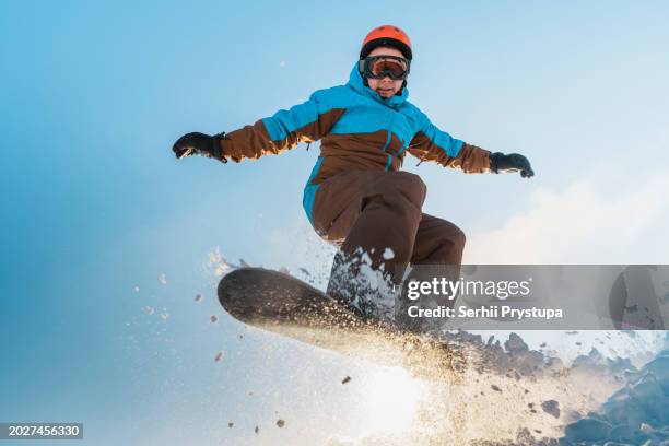 man jumping with a snowboard - skispringen stock-fotos und bilder