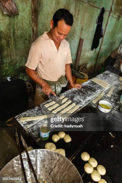 burmese man preparing and selling fresh chinese doughnuts, myanmar - youtiao stock pictures, royalty-free photos & images