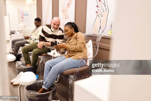 people relaxing while doing their pedicure at a beauty salon - black painted toes stock pictures, royalty-free photos & images