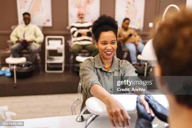happy female client doing a manicure - nail salon stock pictures, royalty-free photos & images