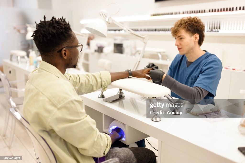 Occupied beautician doing manicure