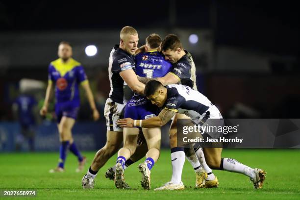 Matt Dufty of Warrington Wolves is tackled by Jack Ashworth , Jordan Lane and Fa'amanu Brown of Hull FC during the Betfred Super League match between...