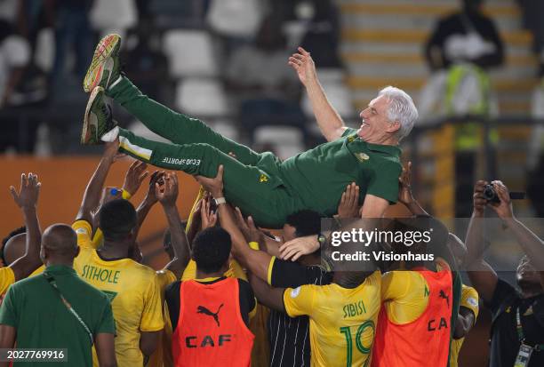 South Africa Coach Hugo Broos is thrown in the air by his players after winning the TotalEnergies CAF Africa Cup of Nations 3rd place match between...