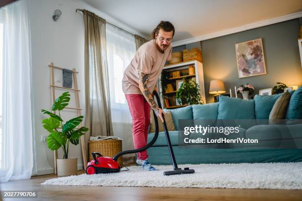 pulizia uomo casa con aspirapolvere - aspirapolvere foto e immagini stock